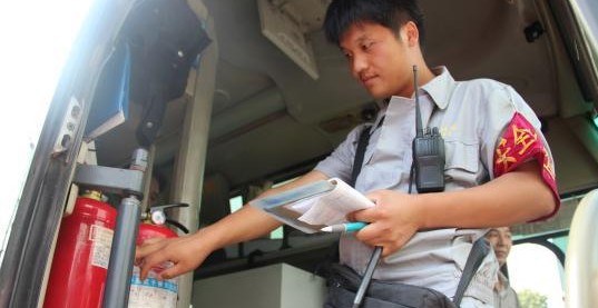 安檢員檢查長途客車內的滅火器圖